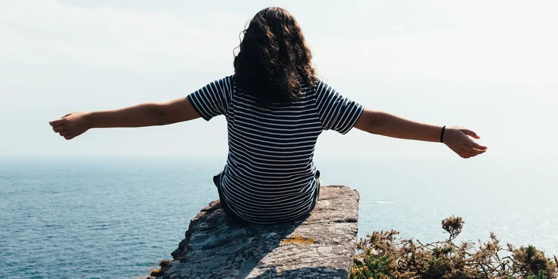 liberty environment woman sitting cliff overlooking sea enviroment