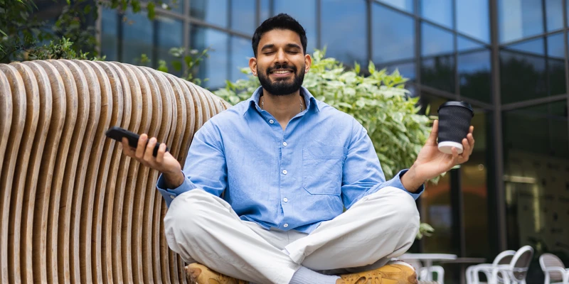 liberty yoga man sitting bench using cell phone